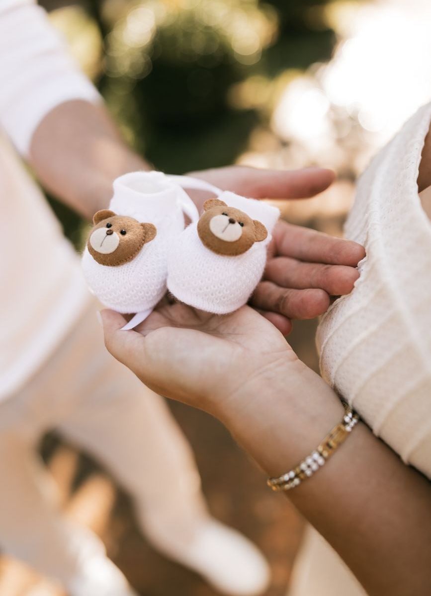 Sepasang Booties Prewalker Katun Lembut dipegang lembut oleh tangan ibu