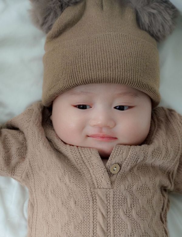 Bayi mengenakan Kardigan Rajut Halus Oat Atelier bernuansa hangat