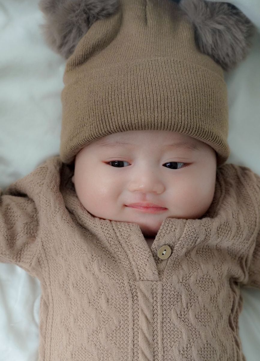 Bayi mengenakan Kardigan Rajut Halus Oat Atelier bernuansa hangat