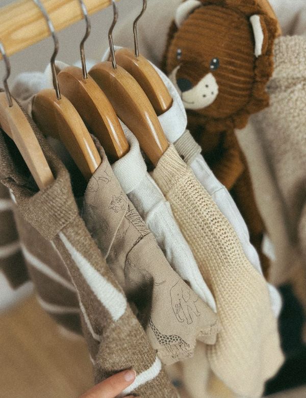 Koleksi Romper Linen Eropa Pasir Hangat tergantung rapi pada hanger kayu