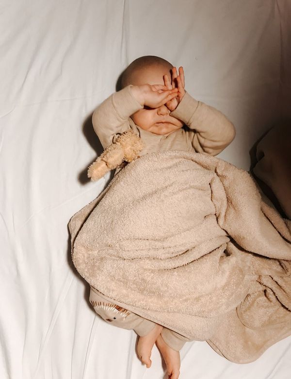 Bayi beristirahat di bawah Selimut Waffle Katun Organik warna pasir